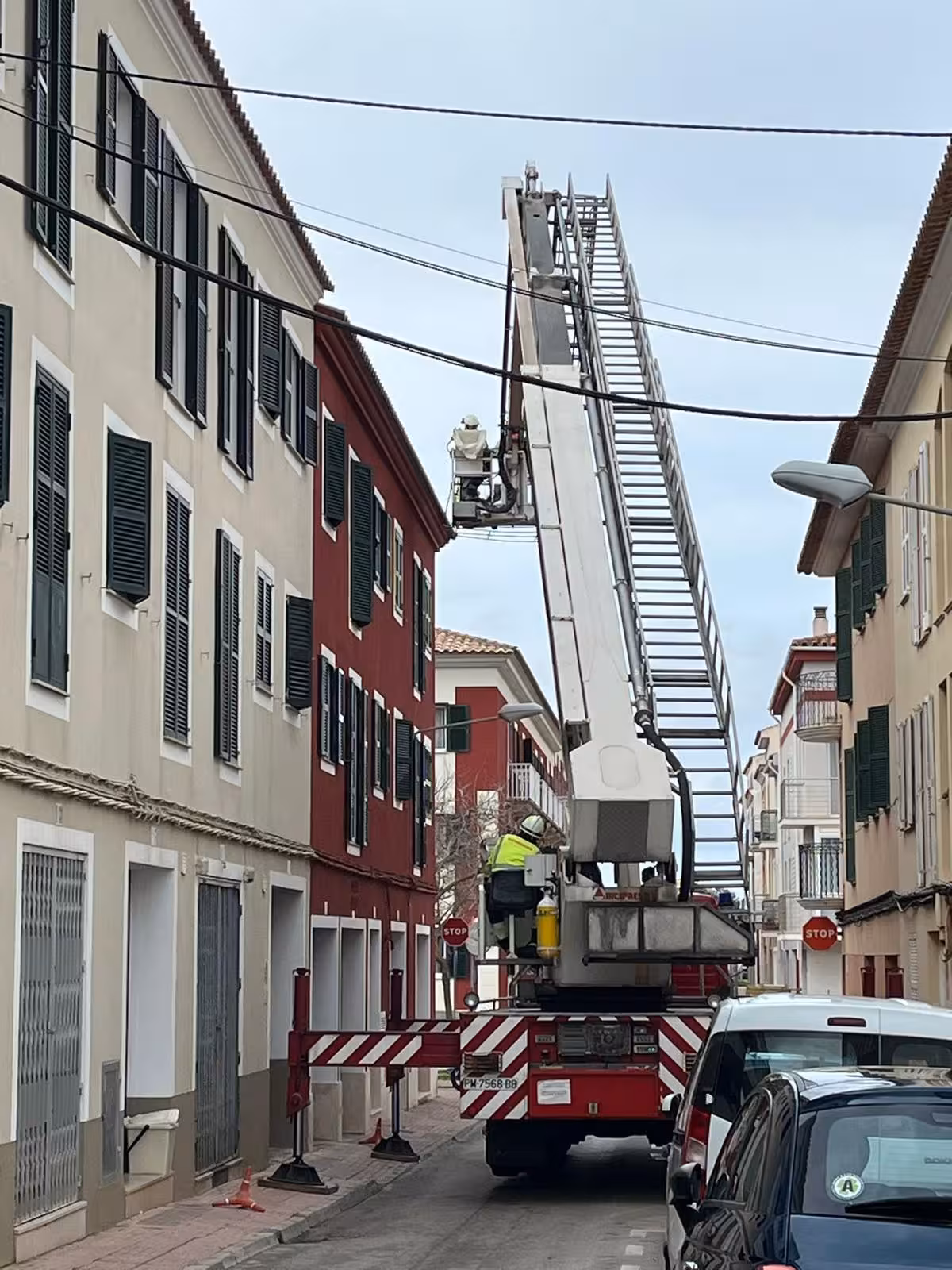 Los bomberos intervienen en Es Castell para retirar un canalón a punto de caer por el viento