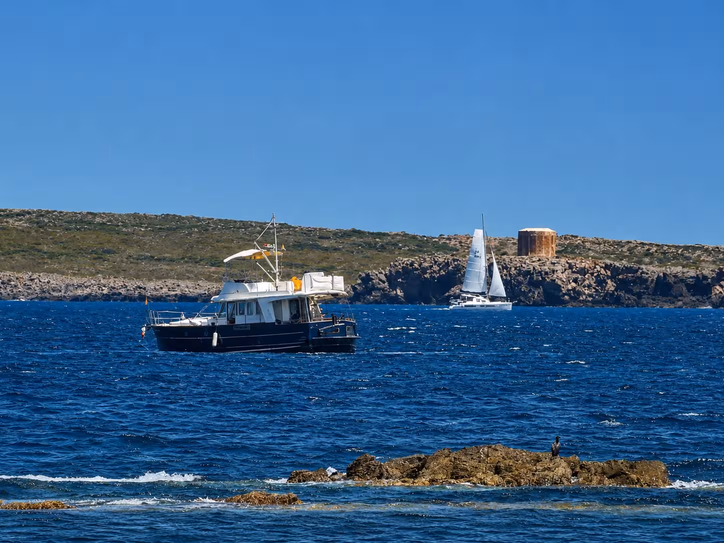 (Vídeo y fotos) Rescatan a dos personas y un perro de un barco varado entre Binimel·là y Cala Pregonda