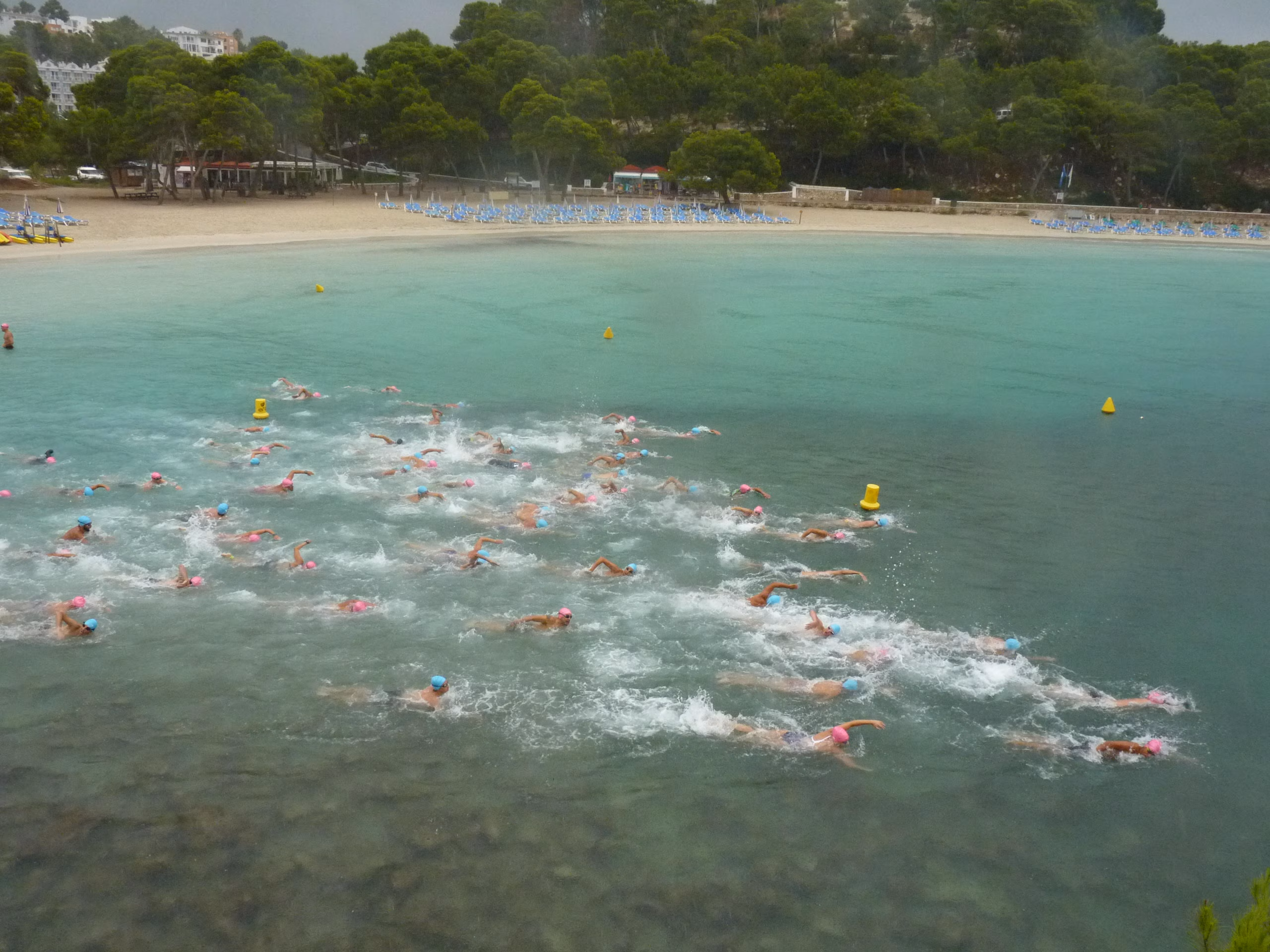 Un centenar de personas se apunta a nadar bajo la lluvia en Cala Galdana